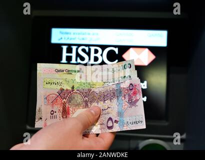 Doha, Qatar - novembre 17. 2019. Qatari rials en main sur le fond de ATM de la Banque HSBC Banque D'Images