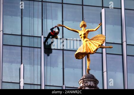 Statue de la ballerine russe Anna Pavlova sur le dessus du dôme de Victoria Palace Theatre et les travailleurs sur la façade de verre Building, Victoria, London, UK Banque D'Images