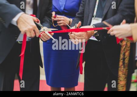 Processus de couper le ruban rouge lors de l'inauguration du nouveau centre commercial Mall building, inauguration de l'exposition, vue rapprochée de red ribbo Banque D'Images