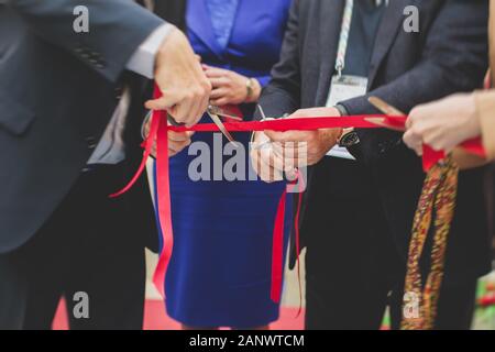 Processus de couper le ruban rouge lors de l'inauguration du nouveau centre commercial Mall building, inauguration de l'exposition, vue rapprochée de red ribbo Banque D'Images