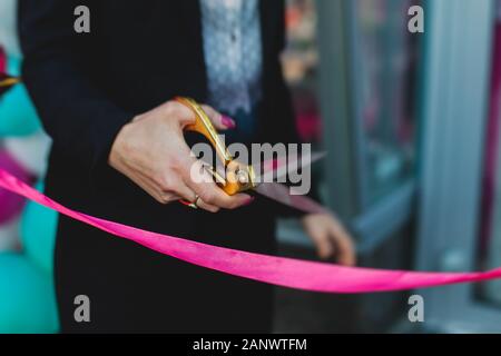 Processus de couper le ruban rouge lors de l'inauguration du nouveau centre commercial Mall building, inauguration de l'exposition, vue rapprochée de red ribbo Banque D'Images