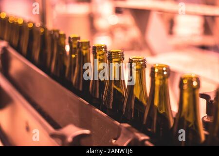 Voir des bouteilles en verre sur le convoyeur à bande, les goulets d'étranglement sur la ligne de production, l'équipement de la brasserie, à l'intérieur de l'usine de vin de liqueur alcool processus, homme Banque D'Images