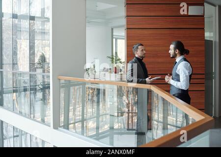 Deux jeunes hommes d'élégance contemporaine à discuter le plan de new deal Banque D'Images