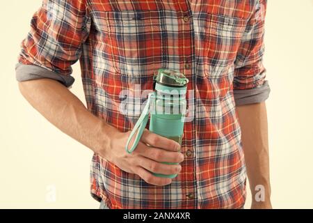 Bouteille réutilisable. Tenir la main ou boire une bouteille d'eau sport fond blanc. Bouteille dans la main des hommes. Le sport et l'équilibre de l'eau concept. Boisson sportive en bouteille. Zéro déchets Eco et de vie. Banque D'Images