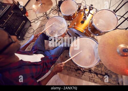 High angle portrait de jeune homme afro-américain à jouer de la batterie avec la bande de musique contemporaine en répétition ou concert en studio, copy space Banque D'Images