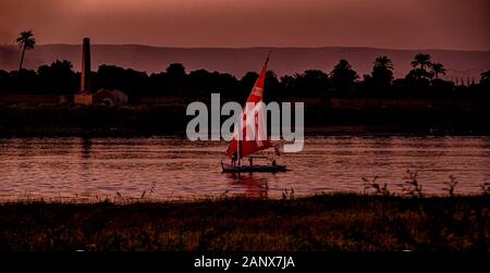 Felucca naviguant sur le Nil près de Louxor, au coucher du soleil Banque D'Images