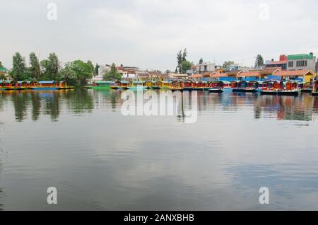 Belle scène de Xochimilco, Mexique ; trajinera boats en attente et le ciel reflète dans l'eau Banque D'Images