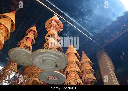 La lumière du soleil s'échappe de la fumée des bobines d'encens accrochées au plafond Du Shau Koi Wan, Temple Tam Kung à Hong Kong. Banque D'Images