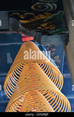 La fumée s'élève des bobines d'encens suspendues au plafond du Shau Kei Wan, Temple Tam Kung à Hong Kong. Banque D'Images