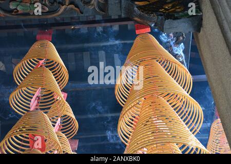 La fumée s'élève des bobines d'encens suspendues au plafond du Shau Kei Wan, Temple Tam Kung à Hong Kong. Banque D'Images