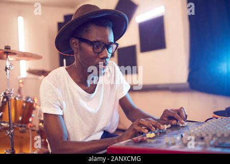 Portrait de jeune homme afro-américain de la musique en studio d'enregistrement à l'aide d'égalisation du son, mixeur copy space Banque D'Images