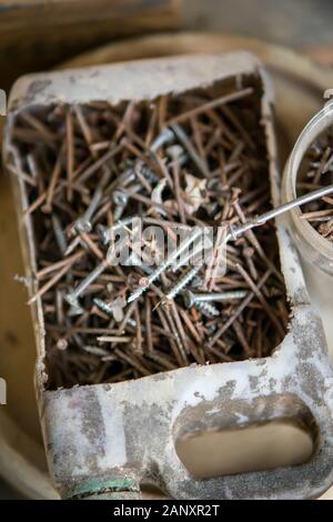 Clous rouillés dans une boîte en plastique à huile recyclée. Vue de dessus. Banque D'Images