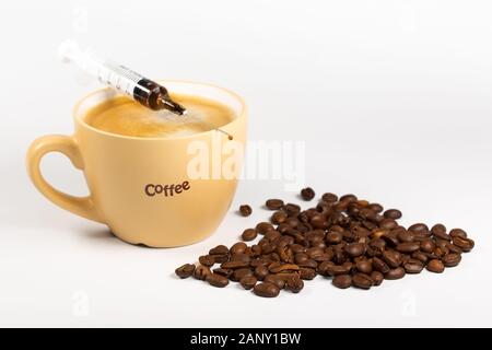 Tasse de café, grains de café et seringue. Concept de la dépendance au café. Banque D'Images