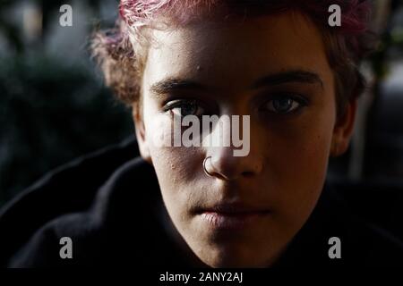 Portrait d'adolescente aux cheveux courts dans le noir, moody light Banque D'Images