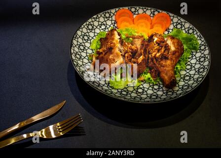 Poulet frit dans une plaque japonaise avec échalote frite sauce douce et sur un fond noir. poulet frit, le plus célèbre de la Hat Yai-Songkhl Banque D'Images