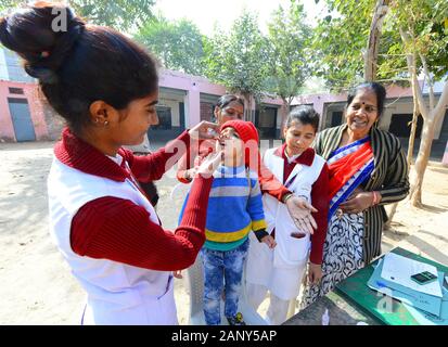 L'Inde. 19 Jan, 2020. Un enfant est administré le vaccin contre la polio par impulsions gouttes ANM travailleur dans une école du gouvernement au cours de la Journée nationale de vaccination contre la poliomyélite "Ravivar' dans Beawar. (Photo by Sumit Mamadou Diop/Pacific Press) Credit : Pacific Press Agency/Alamy Live News Banque D'Images