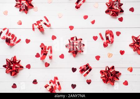 Des rubans rouges et des arcs, des confettis coeurs sur un fond blanc. Copie espace télévision lay. Carte de voeux pour anniversaire, mariage Saint Valentin Banque D'Images