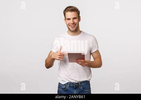 L'homme demande si ami déjà lu l'article, holding digital tablet et périphérique de pointage, smiling, discuter photo avec un collègue, prendre des dispositions en Banque D'Images