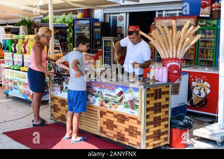 Antalya, Turquie - 26 juillet 2019 : Ice cream Seller en Turquie à Antalya met la crème glacée à un garçon et une femme en journée ensoleillée Banque D'Images