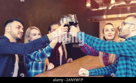 Joyeux millénaires amis à la dégustation et à la consommation de vin rouge au pub Banque D'Images