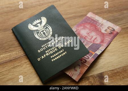 Photo en grand angle d'un passeport sud-africain et d'autres de l'argent sur une surface en bois Banque D'Images
