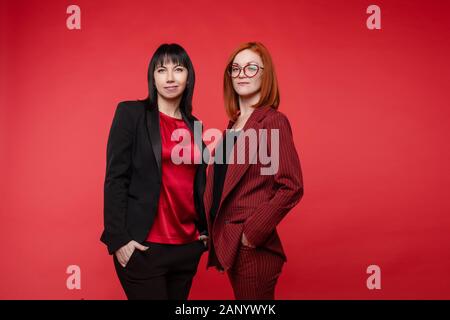 Deux jolies femmes portant des costumes élégants en studio Banque D'Images