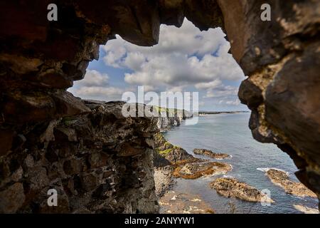 Vue sur la côte d'une arche de mer vers Portrush, prise des ruines du château de Dunluce, Co Antrim. Banque D'Images