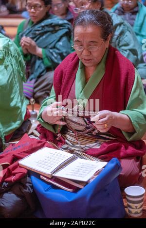 Un bouddhiste dévot adorateur récite des prières en maintenant mala chapelet. Lors d'une Puja Che Tsu dans un temple à Elmhurst, Queens, New York. Banque D'Images