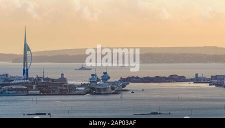 HMS Prince of Wales et HMS Queen Elizabeth amarré dans le chantier naval de Portsmouth avec vue sur la tour des spinnakers. Banque D'Images