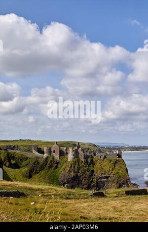 Vue sur le château de Dunluce perché sur le bord de la falaise avec Portrush derrière. Côte De Co Antrim. Banque D'Images