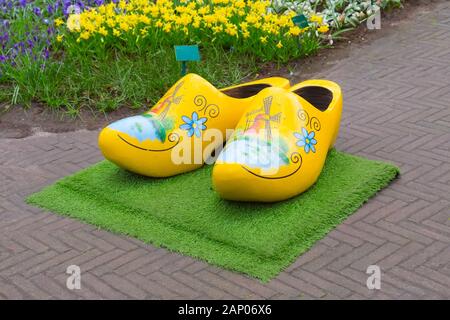 Jaune typique en bois sabots chaussures néerlandais ou klompen, peint avec moulin et parterre derrière, Pays-Bas Banque D'Images