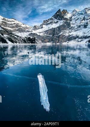 Beau glaçon glace noire sur le lac gelé de l'Oeschinensee dans les Alpes Bernoises Banque D'Images