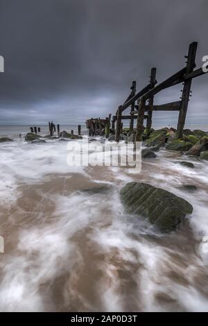 Défenses mer cassée sur la côte de Norfolk à Happisburgh. Banque D'Images