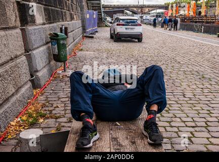 Sans-abri dormant sur banc en bois, Prague en République tchèque. Banque D'Images
