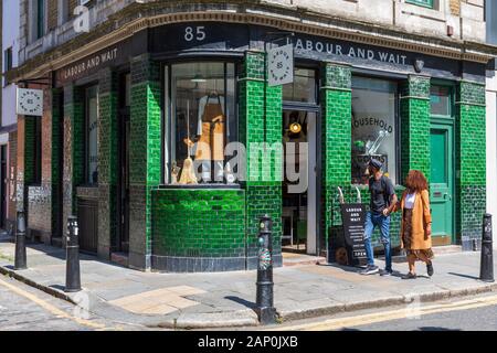 Un jeune couple passé l'attente du travail et accessoires vintage store sur Redchurch Street à Shoreditch. Banque D'Images