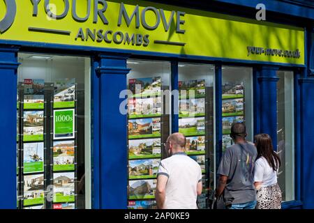 Les personnes à la recherche de maisons à vendre ou louer dans une fenêtre d'agents immobiliers. Banque D'Images