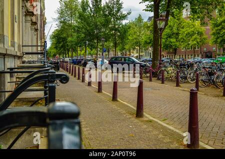 Amsterdam, Pays-Bas, août 2019. Une rue au centre : vue sur le vert sombre des garde-corps de la maisons avec entrée indépendante sur la rue et le jeu Banque D'Images