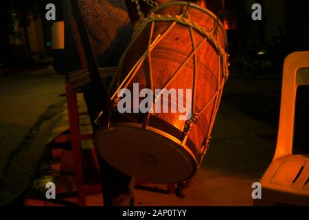 Gurgaon, Inde, vers 2020 - Photo d'un tambour ou un Dhol menées autour d'une personne la nuit. Le dhol est accroché autour du cou et frappé par un CIST Banque D'Images