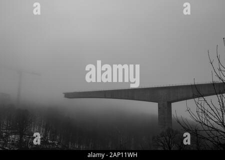 Épais brouillard d'hiver et construction de ponts en béton à grande vitesse dans la ville de Gabrovo, dans le nord de la Bulgarie, en Europe. Partie du périphérique, sponsorisé par l'Union européenne. Image en noir et blanc Banque D'Images