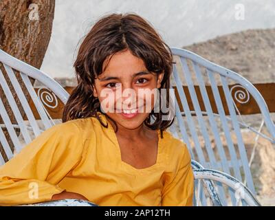 Portrait d'une petite fille locale, assise dans un fauteuil en métal Banque D'Images