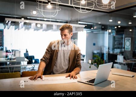 Portrait de l'architecte travaille avec le plan directeur de l'office Banque D'Images