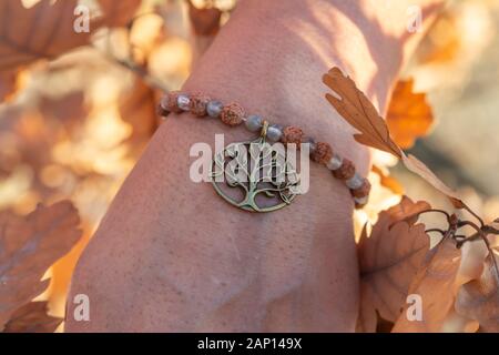 Homme de main poignet en automne nature avec pierre labradorite perles rudraksha minéral et métal bracelet pendentif en cuivre Banque D'Images