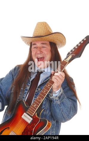 Un bel homme autochtone dans une veste de jeans et un chapeau de cowboy et permanent à jouer de la guitare, isolée pour fond blanc Banque D'Images