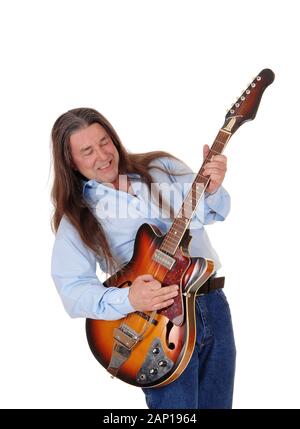 Un musicien heureux jouant de sa guitare avec sa longue chevelure brune, chant, isolée pour fond blanc Banque D'Images