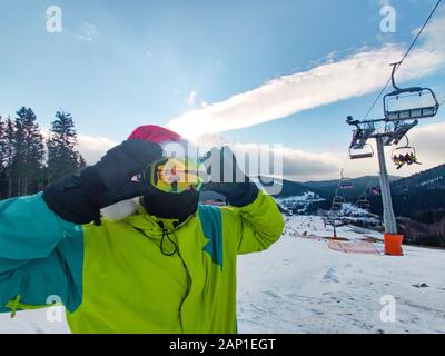 Homme heureux en tenue de ski avec le père Noël Noël rouge hat au winter mountains hill Banque D'Images