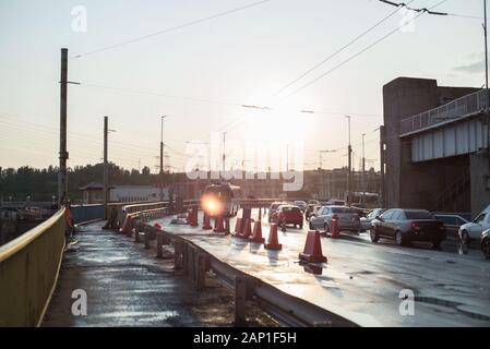 Des travaux de réparation. Réparation de la route sur le pont à l'entrée de la ville. Les voitures sont en circulation. La signalisation routière limitant les voyages sont indiqués. Banque D'Images