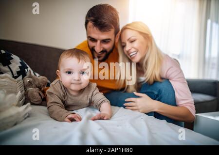 Heureux parents changeant de couches à leur bébé garçon. Banque D'Images