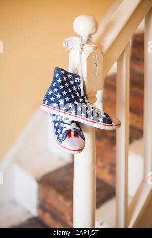 Une paire de stars and stripes chaussures haut haut accroché sur une rampe Banque D'Images