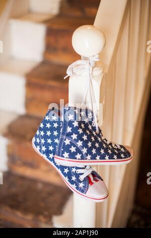 Une paire de stars and stripes chaussures haut haut accroché sur une rampe Banque D'Images