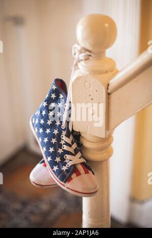 Une paire de stars and stripes chaussures haut haut accroché sur une rampe Banque D'Images